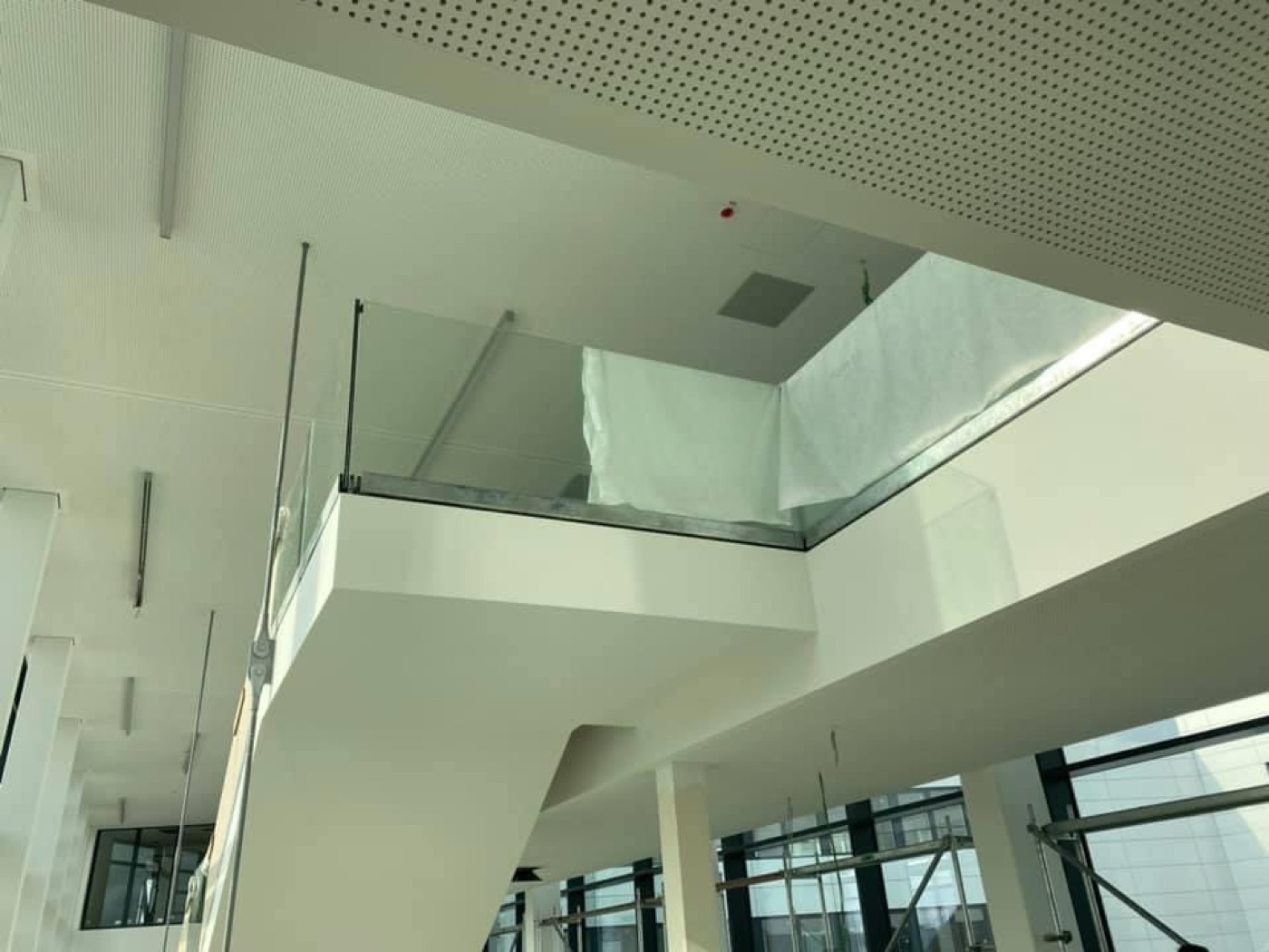 Lichthof mit Glasgeländern und weißer Decke